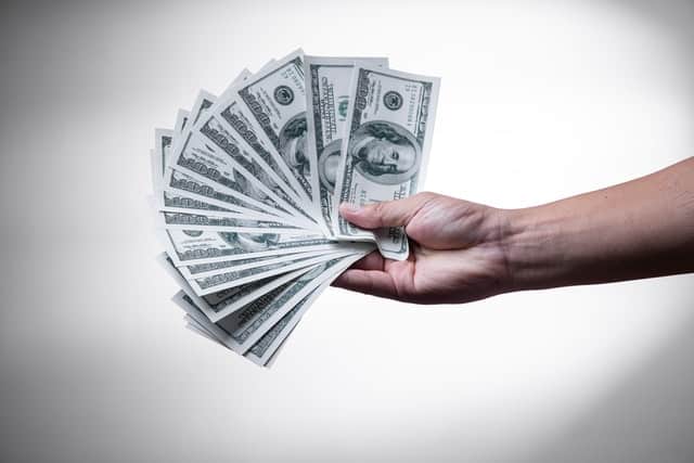 hand holding hundred dollar bills for spousal support in texas divorce