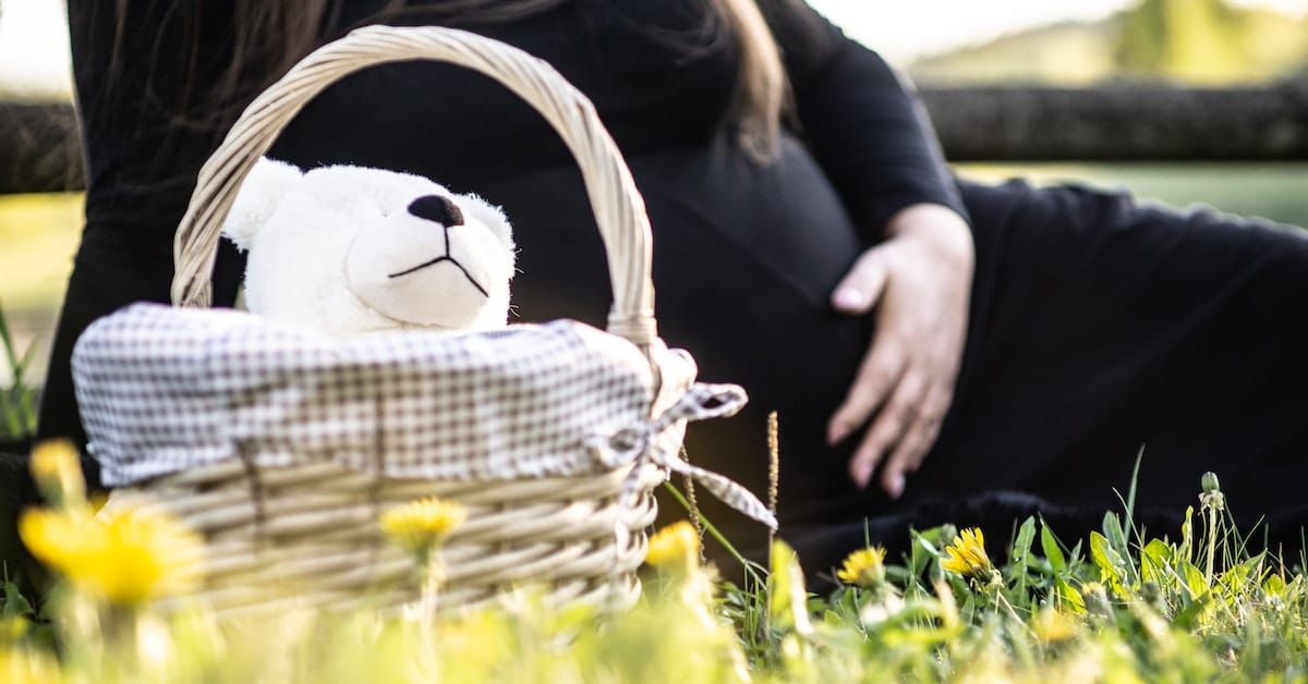 pregnant woman with stuffed animal and basket outside before texas divorce