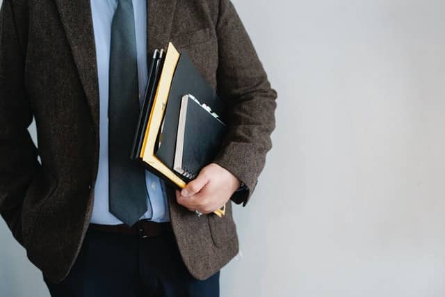 man wearing a suit with notebooks getting divorced without a lawyer in texas
