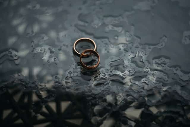 two wedding rings on wet surface of two people getting cheap divorce in texas