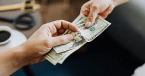 person handing cash to another person for spousal support in texas