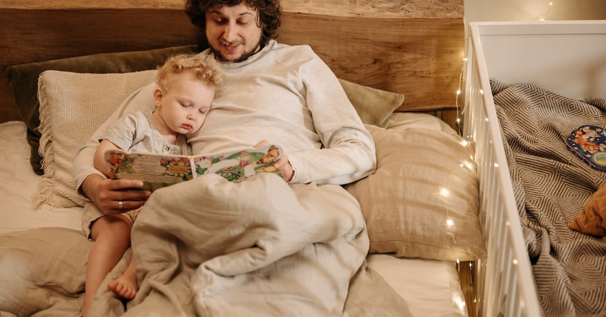 father reading to child in bed after texas divorce