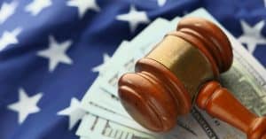 judges gavel on top of cash and american flag
