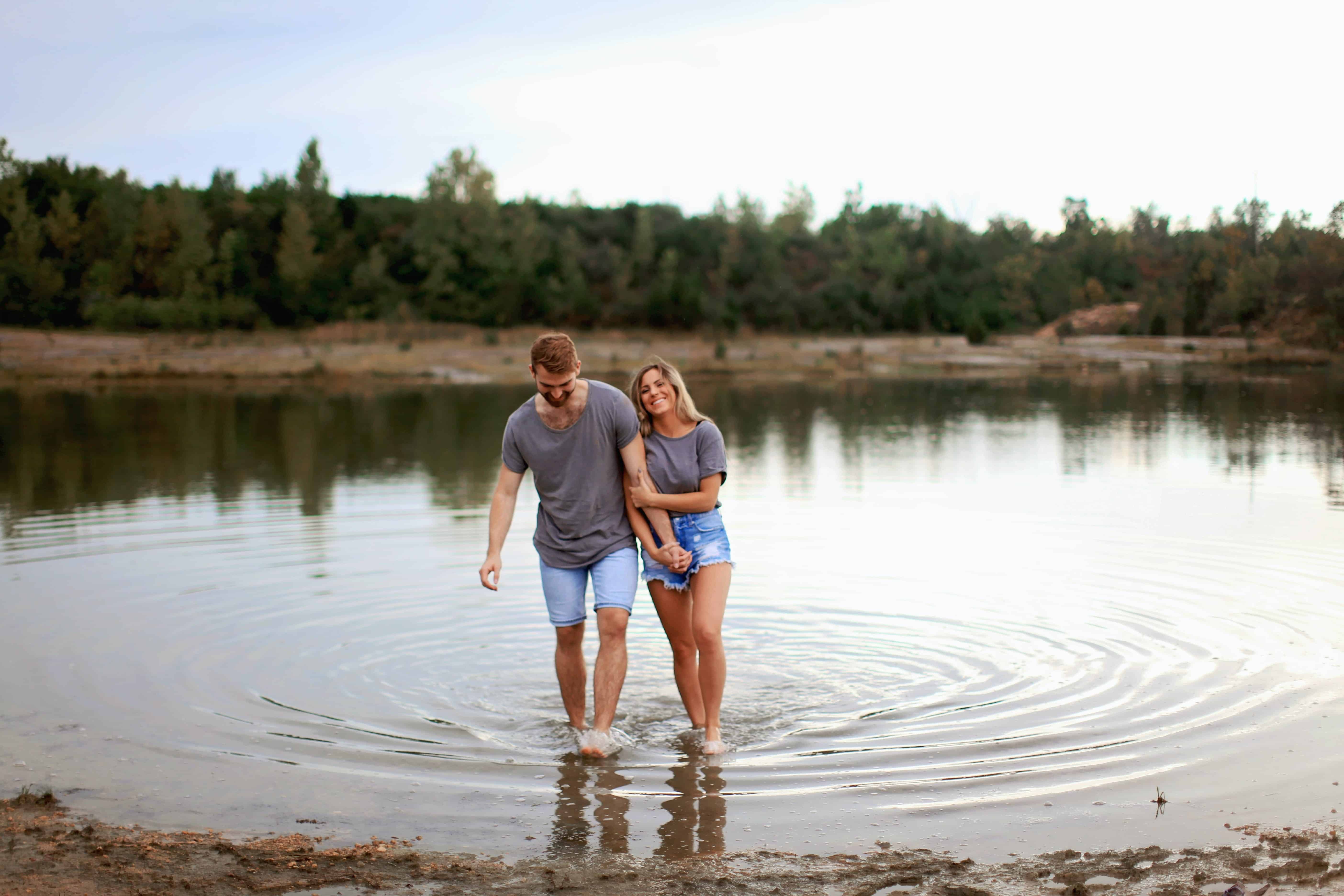 couple with an informal marriage in texas walking hand in hand in a pond