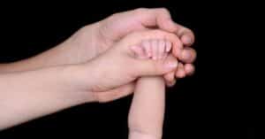 hands of parents with infant in texas with mandatory child support