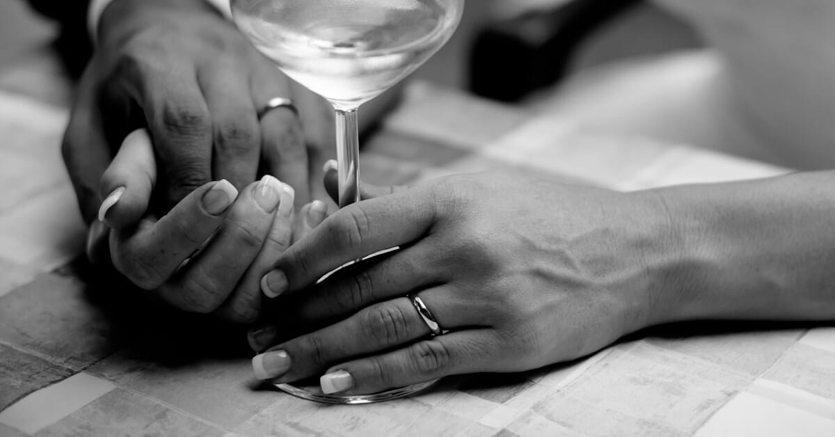 hands with wedding rings and fake texas marriage certificate