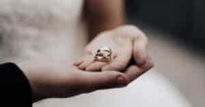 holding wedding rings for couple with marriage contract in texas